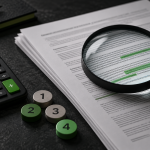Calculatrice et loupe posées sur un contrat pour illustrer la lecture des conditions de mise